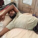 A young man in hospital with a live cow after being bitten by a snake